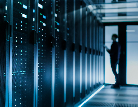Silhouette of a person standing in a server room 