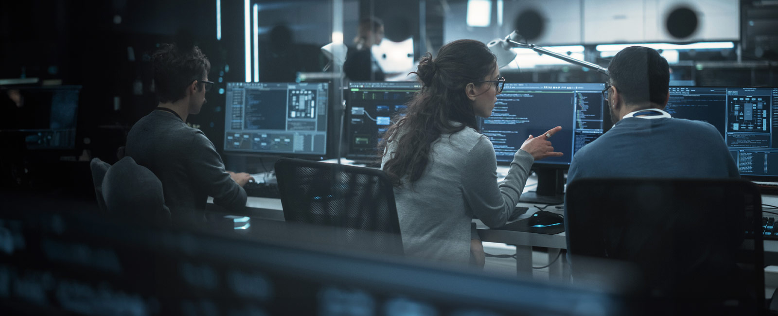 Coworkers looking at their computers, having a discussion in a modern office
