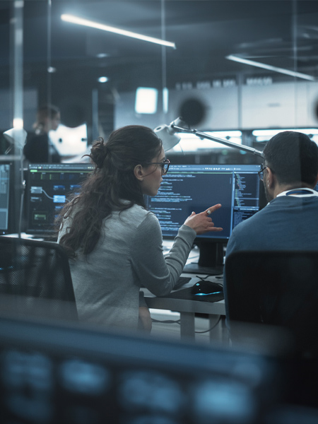 Coworkers looking at their computers, having a discussion in a modern office
