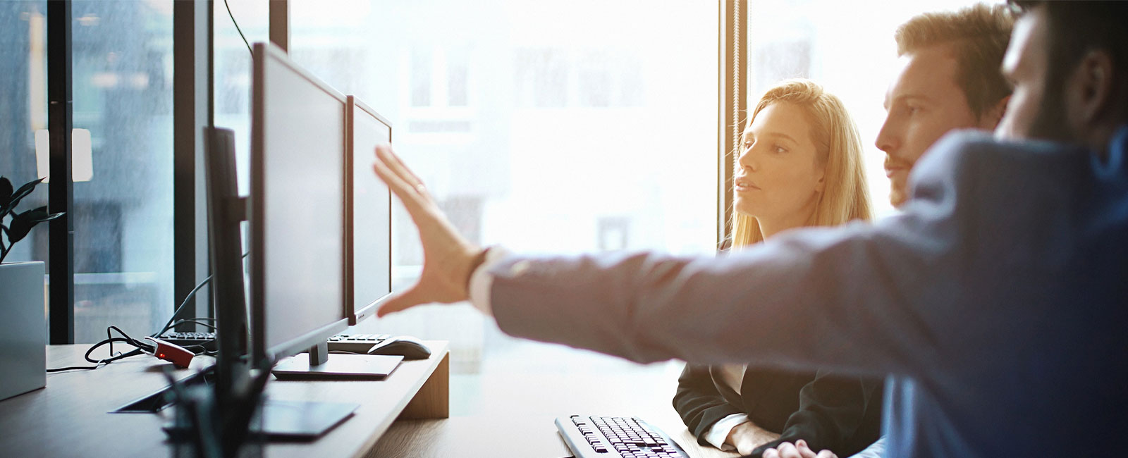 Closeup side view of group of software developers working at an IT office