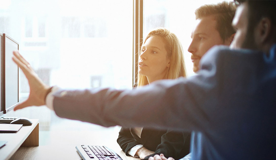 Closeup side view of group of software developers working at an IT office