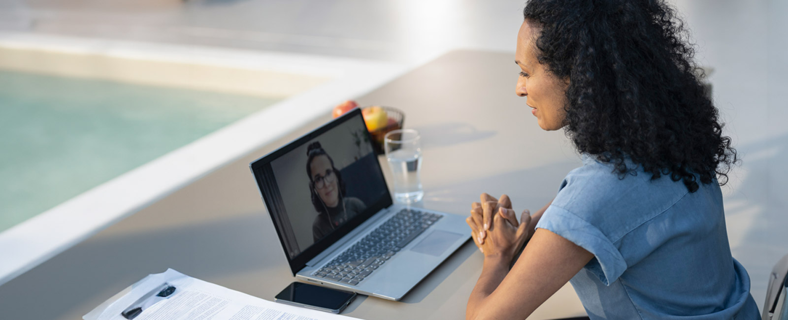 Woman watching a lecture on a laptop and taking notes